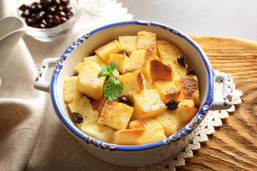 Delicious bread pudding with currant in bowl on table