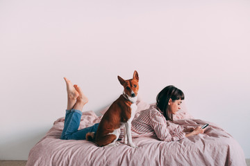 Obraz premium Hipster girl lounging in bed with coffee
