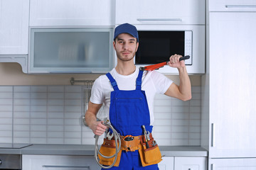 Handsome young plumber in kitchen