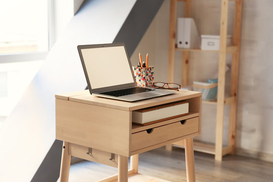 Stand-up desk with laptop in room