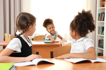 Beautiful elementary schoolgirls studying in classroom