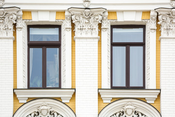 Fototapeta premium Ornate building with vintage windows and brick wall background