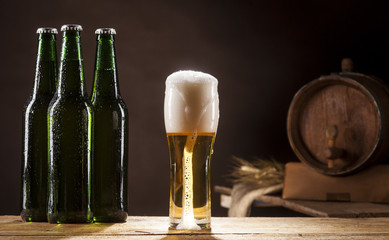 Beer barrel with three bottles and mug on brown background