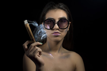 Young girl with  sunglasses smoking cigar
