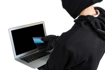 Hacker using laptop and credit card