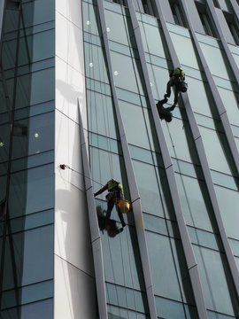 London, United Kingdom - March 14, 2016: Construction abseilers fix curtain wall of building