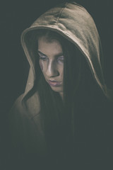 Portrait of a young girl with artistic make up wearing a cardigan with hood