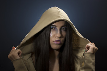 Portrait of a young girl with artistic make up wearing a cardigan with hood