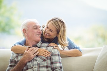 Senior woman embracing a man in living room