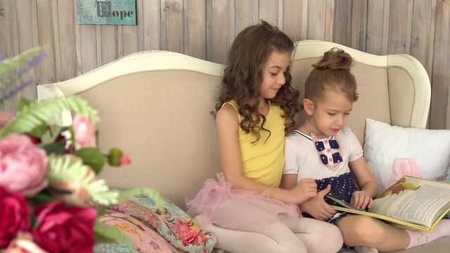 Little girls are reading a book