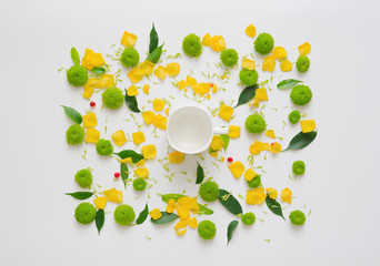 Cup for coffee or tea with pattern with petals of rose flowers, ficus leaves, hearts and ripe rowan on white background. Overhead view. Flat lay.