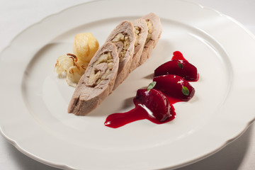Apple tartar stuffed pork fillet with beetroots and baked potatoes. on white plate