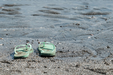 砂浜に脱ぎ捨てられたサンダル