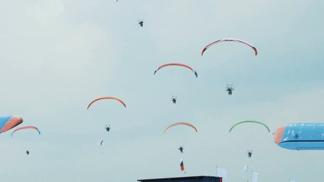 Paraglider flies over the land. Paragliding. Powered paraglide flying in the sky. Parachute