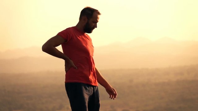 Sad, unhappy man standing on hill during sunset, super slow motion 240fps
