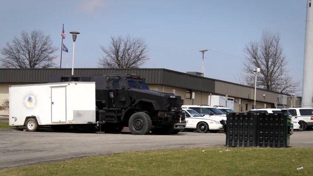Establishing shot of Police Station with squad cars and SWAT Vehicle
