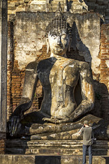 Old statue at Wat Phra Si Ratanamahathat and traveler