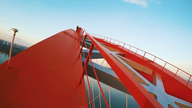 Extreme sports. Young guys perform stunts on top. Rufer climb on the bridge.