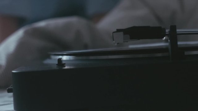 CU female hand turning on modern vinyl turntable player. 4K UHD RAW edited footage