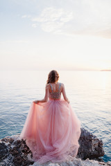 Fototapeta na wymiar woman in rose dress on beach