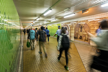 Commuters rushing to work through the passenger tunnel uner a station.