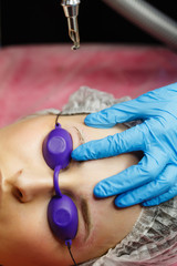 Laser removal of tattoo eyebrows. Shooting closeups. Cosmetic medical procedure in a beauty salon.