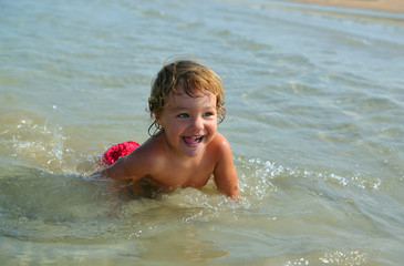 happy child bathing in sea