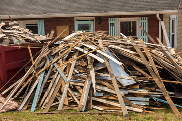Lumber Pile Sticked In Front Of Dumpster Near Home Being Renovated