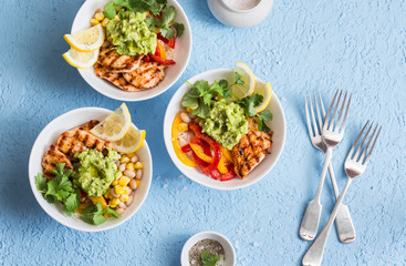 Chicken fajitas bowls on a blue background, top view. Flat lay