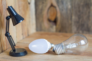 Small table lamp made of black plastic on a wooden background. 