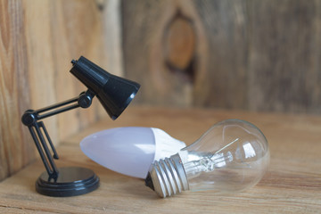 Small table lamp made of black plastic on a wooden background. 