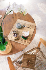 Cup of cappuccino on a wooden table. Bamboo style. Wicker bag on the chair