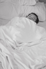 Closeup sick child sleep on hospital bed textured background in black and white tone