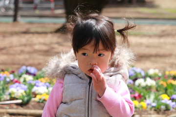 花の咲く公園で遊ぶ女の子