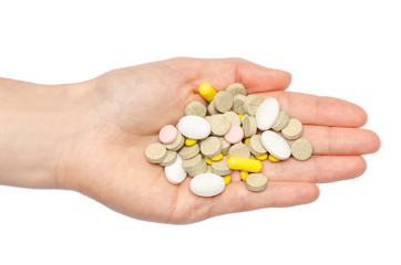 hand of young girl holding pills.