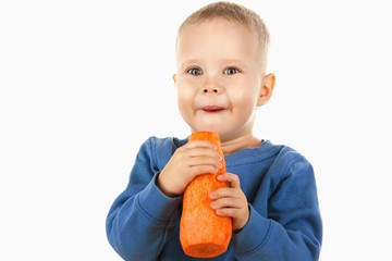 Happy baby boy eating carrot, isolated