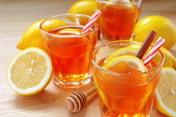 lemon tea with slice of fresh lemon in clear glass on wooden rustic background.