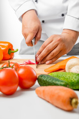 close up hands of chef cut radish slices on a wooden board