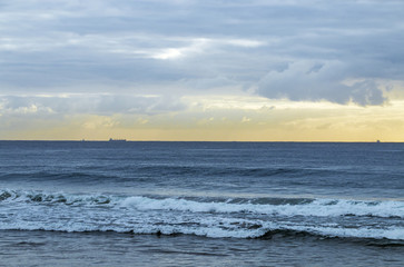Obraz premium Morning Ocean Against Cloudy Sky with Ships on Horizon