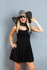 Happy young woman wearing a hat and sunglasses