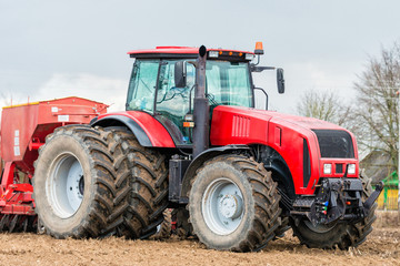 Obraz premium Farmer tractor working in the field. Spring time for sowing. Planting crops.