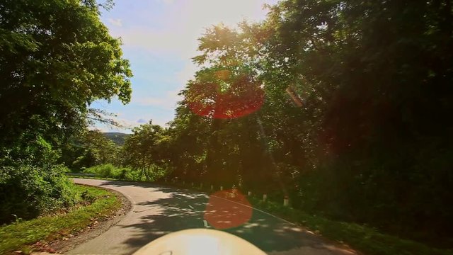 Camera Moves along Curvy Country Road among Hilly Landscape
