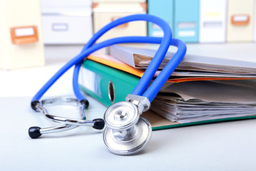 Folder file, stethoscope and note on the desk. blurred background.