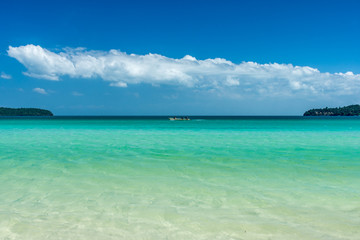 Naklejka na ściany i meble Tropical bay with a blue sky and clear calm water.