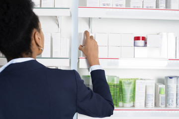 Businesswoman Choosing Medicine In Pharmacy