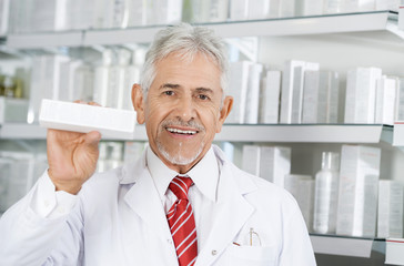 Pharmacist Smiling While Holding Medicine Box