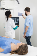 Obraz premium Radiologists Holding X-ray And Digital Tablet With Patient In Fo