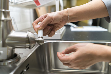 Woman hand opening the water tap