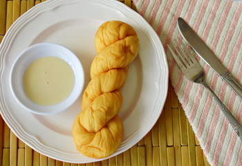 soft twist bread dipping with sweetened condensed milk