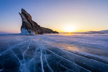 Baikalsee bei warmem Sonnenaufgang im Winter. Schöne Felsen und Risslinien auf Eis. © pakorn482137
